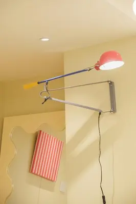 a lamp hanging from a ceiling with a red chair at \u5bc5\u30db\u30c6\u30eb \u5fa1\u5f92\u753a Tora Hotel Okachimachi in Tokyo