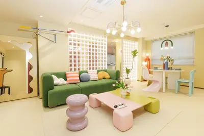a living room with a green couch and a table at \u5bc5\u30db\u30c6\u30eb \u5fa1\u5f92\u753a Tora Hotel Okachimachi in Tokyo