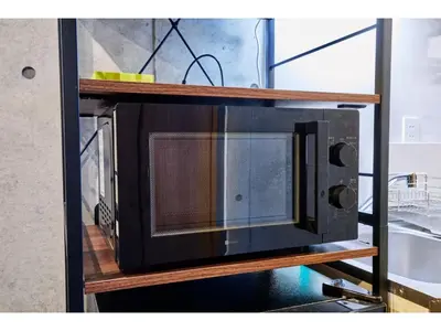 a black microwave on a wooden shelf at LIFE TOWN OSHIAGE - Vacation STAY 20456 in Tokyo