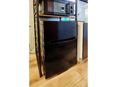 a black refrigerator in a kitchen with a microwave at LIFE TOWN OSHIAGE - Vacation STAY 20456 in Tokyo