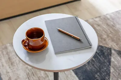 a cup of coffee and a notebook on a table with a pen at Daffitto\u62bc\u4e0aI in Tokyo