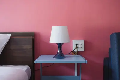 a lamp on a blue table next to a bed at ViLLA SAKURA\u65d7\u306e\u53f0 II\u756a\u9928 in Tokyo
