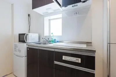 a small kitchen with a sink and a microwave at ViLLA SAKURA\u65d7\u306e\u53f0 II\u756a\u9928 in Tokyo