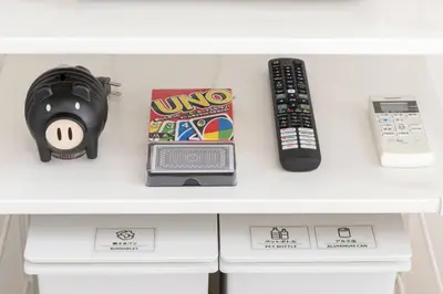a table with a remote control and a game controller at House Hotel Nakano TNA in Tokyo