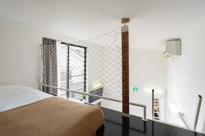a bedroom with a bed and a large window at House Hotel Nakano TNA in Tokyo