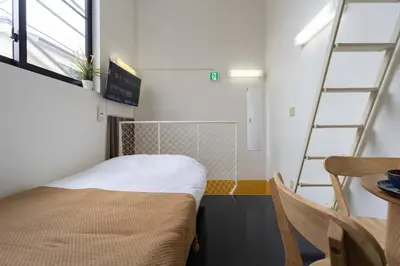 a room with a bed and a table and a ladder at House Hotel Nakano TNA in Tokyo
