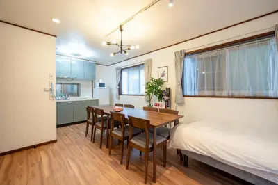 a bedroom with a dining room table and a bed at Familia Kamata 1 in Tokyo