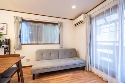 a living room with a couch in front of a window at Familia Kamata 1 in Tokyo
