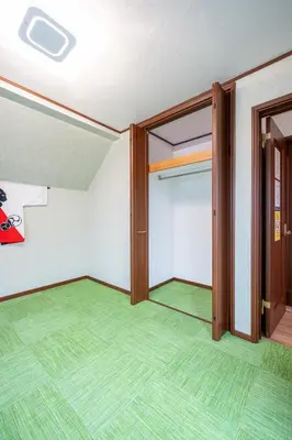 an empty room with a door and green carpet at Familia Kamata 1 in Tokyo