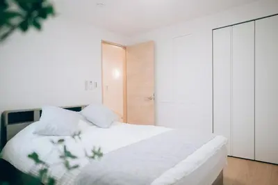 a bedroom with a white bed with white sheets at Metronest \u4e09\u8ed2\u8336\u5c4b in Tokyo