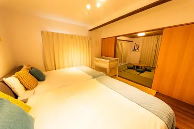 a bedroom with a large white bed and a desk at Lille Kameari in Tokyo