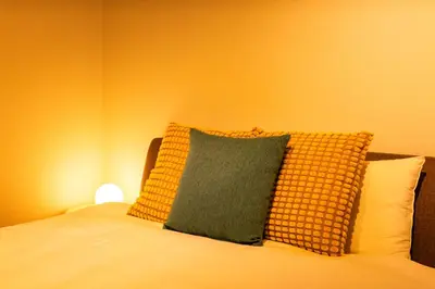 a bed with a green pillow on top of it at Lille Kameari in Tokyo
