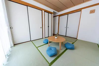 an empty room with a table and blue chairs at Lille Kameari in Tokyo