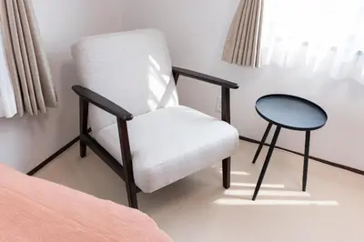 a chair and a table in a bedroom at Lille Kameari in Tokyo