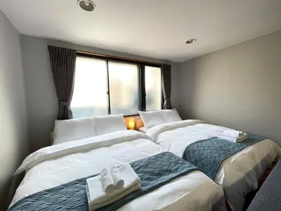 two beds in a room with a window at \u30a2\u30e0\u30db\u30c6\u30eb in Tokyo