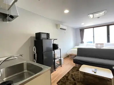 a kitchen and a living room with a sink and a bed at \u30a2\u30e0\u30db\u30c6\u30eb in Tokyo