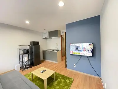 a living room with a couch and a tv on a wall at \u30a2\u30e0\u30db\u30c6\u30eb in Tokyo