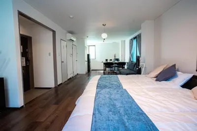 a large white bed in a room with a table at studio aoi 202 in Tokyo