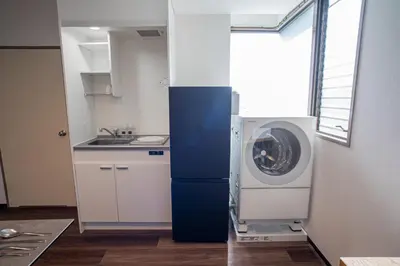 a kitchen with a washing machine next to a window at studio aoi 202 in Tokyo