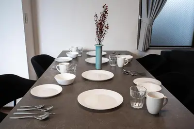 a table with white plates and utensils on it at studio aoi 202 in Tokyo