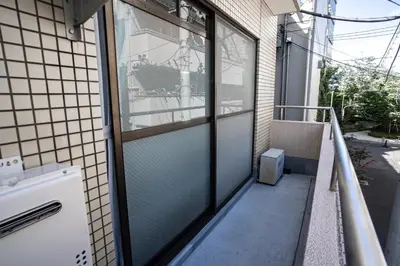 a balcony with glass doors on a building at studio aoi 202 in Tokyo