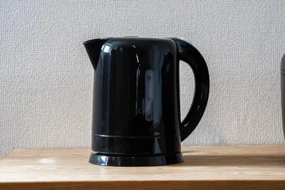 a black coffee cup sitting on a wooden table at studio aoi 202 in Tokyo