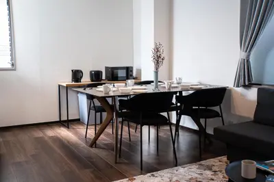 a dining room table with black chairs in a living room at studio aoi 202 in Tokyo