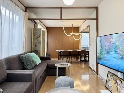 a living room with a couch and a tv and a table at Oji kajiwara house in Tokyo