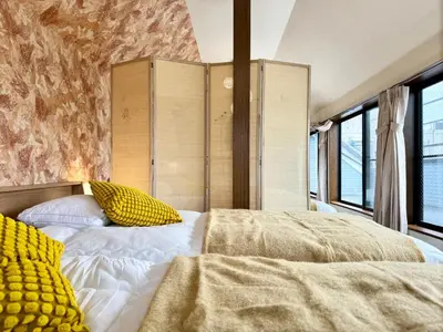 a bedroom with two beds with yellow pillows at Oji kajiwara house in Tokyo