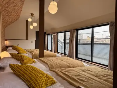 two beds in a room with large windows at Oji kajiwara house in Tokyo