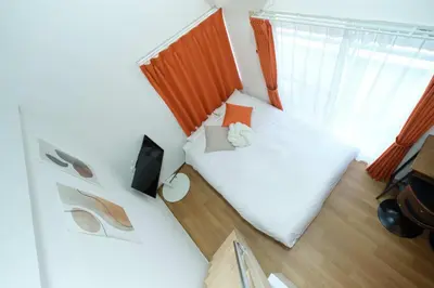 a small bedroom with a white bed and a window at monthly Sakura Yoyogi in Tokyo