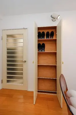 a room with a closet with shoes on shelves at monthly Sakura Yoyogi in Tokyo