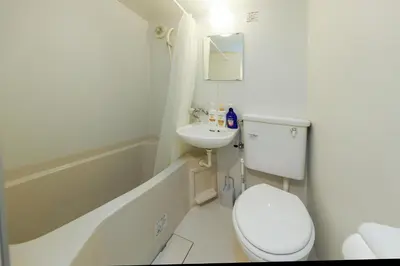 a white bathroom with a toilet and a sink at monthly Sakura Yoyogi in Tokyo