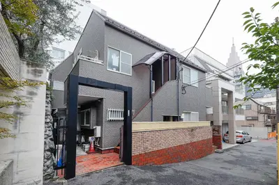a house with a black door on a street at monthly Sakura Yoyogi in Tokyo