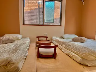 a room with two beds and a table and a window at S1\u6d89\u8c37\u4e2d\u5fc3 \u4ea4\u901a\u67a2\u7ebd \u6d89\u8c37\u8f66\u7ad96\u5206\u949f \u65e0\u9650\u89c6\u91ce \u6700\u59272\u4eba Shibuya center 6 mins to ST Max 2P \u76f4\u8fbe\u65b0\u5bbf \u6d89\u8c37 \u8868\u53c2\u9053 \u54c1\u5ddd \u6c60\u888b \u4e0a\u91ce \u4ee3\u4ee3\u6728 \u94f6\u5ea7 \u539f\u5bbf in Tokyo