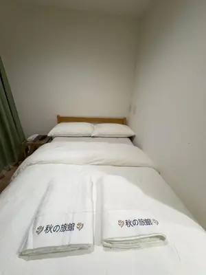 a white bed with two towels on top of it at \u79cb\u306e\u65c5\u9928 in Tokyo