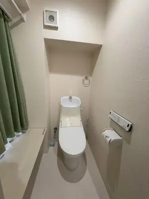 a small bathroom with a toilet with a green curtain at \u79cb\u306e\u65c5\u9928 in Tokyo