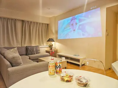 a living room with a couch and a tv on the wall at OPEN#\uc2e0\uc8fc\ucfe05\ubd84#\uc2dc\ubd80\uc57c10\ubd84#\ud3b8\uc758\uc8102\ubd84#\ucd5c\ub3008\uba85#\uc608\uc05c\uc9d1#\uce68\uc2e43#114m2#\uce68\ub3005#\ube54\ud504\ub85c\uc81d\ud130 in Tokyo