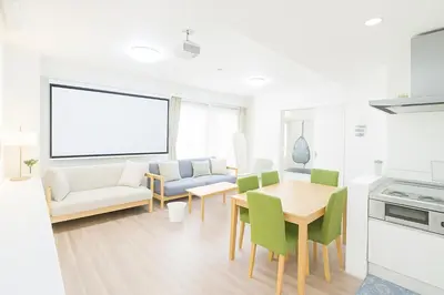 a white living room with a table and chairs at OPEN#\uc2e0\uc8fc\ucfe05\ubd84#\uc2dc\ubd80\uc57c10\ubd84#\ud3b8\uc758\uc8102\ubd84#\ucd5c\ub3008\uba85#\uc608\uc05c\uc9d1#114m2#\uce68\ub3005#\ube54\ud504\ub85c\uc81d\ud130 in Tokyo