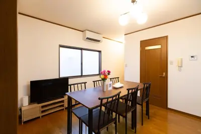 a dining room with a table and chairs and a television at Kotori Itabashi in Tokyo