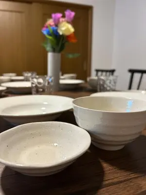 a wooden table with white bowls and flowers on it at Kotori Itabashi in Tokyo