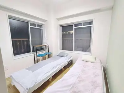 two beds in a room with two windows at Takadababa\u9ad8\u7530\u9a6c\u573a\u4e2d\u5fc3\u5730\u5e26#\u9ad8\u901f\u65e0\u9650\u5236\u7f51 # \u667a\u80fd\u9a6c\u6876 #\u5e72\u6e7f\u5206\u79bb #\u9ad8\u7ea7\u516c\u5bd3104 in Tokyo