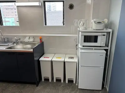 a small kitchen with a sink and a microwave at Art House Katsushika in Tokyo