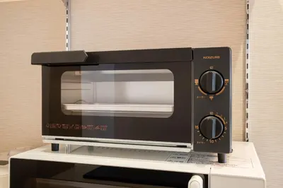 a black microwave sitting on top of a counter at Terrace Tokyo Otsuka in Tokyo
