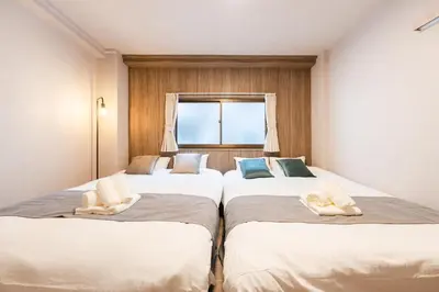 two beds in a room with a window at Terrace Tokyo Otsuka in Tokyo
