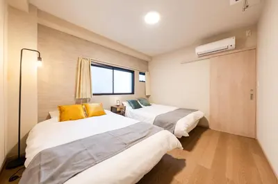 a bedroom with two beds and a window at Terrace Tokyo Otsuka in Tokyo
