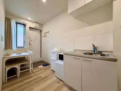 a kitchen with white cabinets and a counter top at Hanshe Hotel Sumida No 3, Skytree & Asakusa 天空树 浅草 in Tokyo