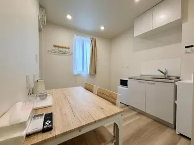 a kitchen with a large wooden table in a room at Hanshe Hotel Sumida No 3, Skytree & Asakusa 天空树 浅草 in Tokyo