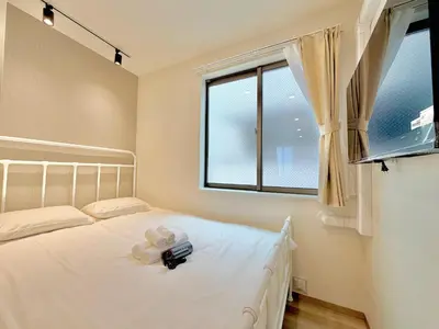 a bedroom with a white bed and a window at Hanshe Hotel Sumida No 3, Skytree & Asakusa 天空树 浅草 in Tokyo