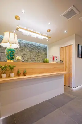 a lobby with a counter with potted plants at Nakano World Hotel in Tokyo